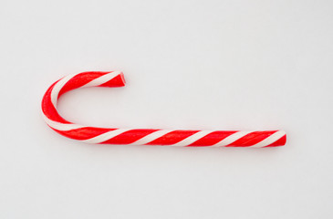 A red and white striped candy cane on a white background.