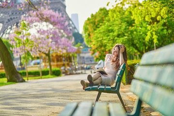 Beautiful young woman in Paris, reading a book