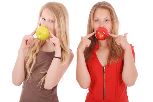 Two girls hold in aples fresh cherries