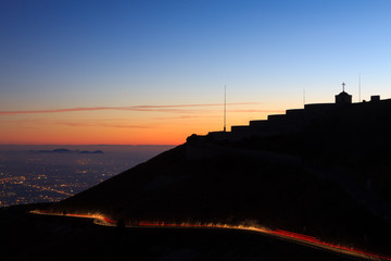 Light trails with building in silhouette.