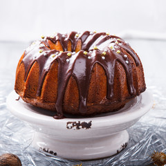 Traditional Christmas Fruit Cake in chocolate coating with nuts decor on a Christmas decoration background.selective focus.