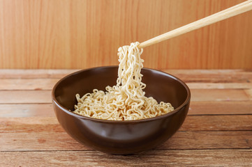 Noodle in brown bowl with wooden chopsticks