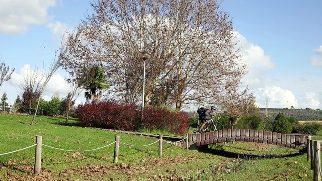 mountain bicycle riding on a public garden with a wooden bridge