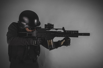 sniper, airsoft player with gun, helmet and bulletproof vest on