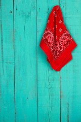 Red bandanna hanging on rustic teal blue background