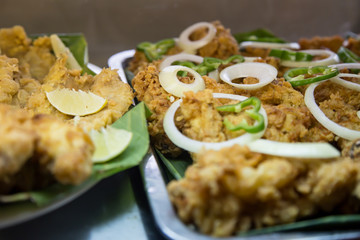 fried fish with onion and pepper, selective focus on central.