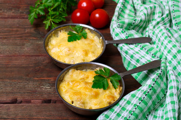 French cuisine. Сhicken with mushrooms baked with cheese in a cocotte
