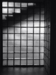 Black and white glass wall texture with silhouette of staircase behind it