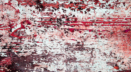 Flaking blood red paint on white wood, grunge background texture.