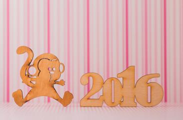 Wooden sign of monkey and inscription of 2016 year on pink strip