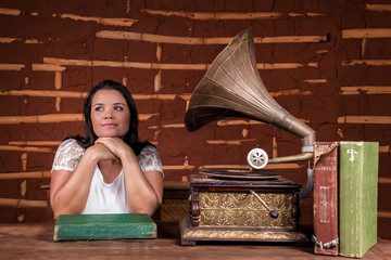 A girl listening to music on an old gramophone with some album discs