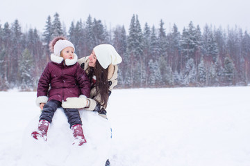 Fototapeta na wymiar Little girl ang happy mother enjoy winter snowy day