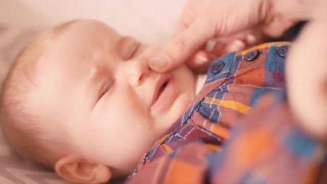 Close up of a mother wiping her baby's nose 