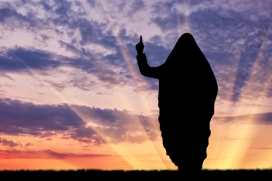 Silhouette of man with hand gesture against cloudy sky