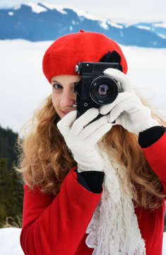 Photographer woman outdoors taking pictures in winter season