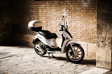 scooter stands parked near the wall
