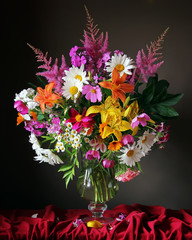 Still life with a bouquet of cultivated flowers in a transparent