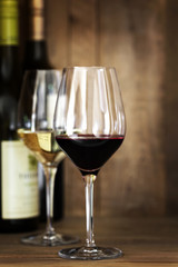 Red and White Wine Glasses and Bottles over Oak