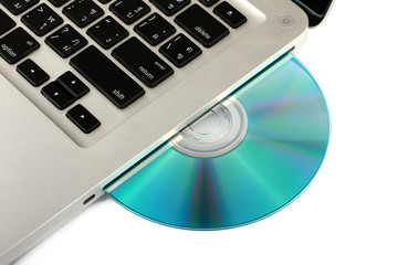 DVD, CD disk in the drive of a laptop white background, close-up, isolated