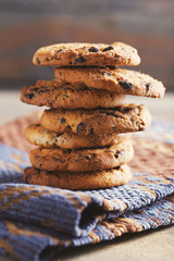 Fototapeta na wymiar Cookies with chocolate crumbs on ornament napkin against blurred background, close up