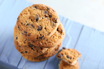 Cookies with chocolate crumbs on blue wooden table against blurred background, close up