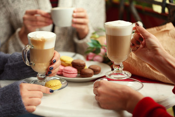 Women meeting in cafe and drinking latte