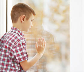 Sad boy sitting near window