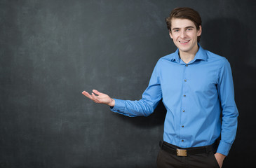 Portrait of a smart young man standing against gray background