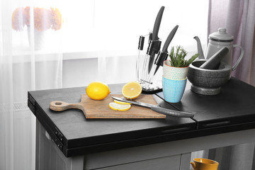 Sliced lemon and tableware on kitchen table, close up