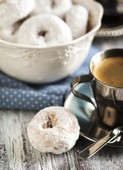 Sweet donuts with icing sugar and cup of coffee