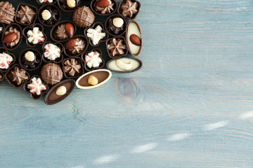 Assorted chocolate candies on wooden background, close up