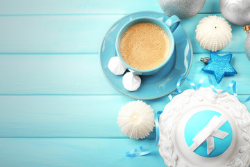 Tasty cupcake with bow, coffee cup and Christmas toys on color wooden background