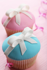 Tasty cupcakes with bow on color wooden background