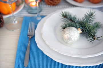White plates with flatware on a Christmas table, close up