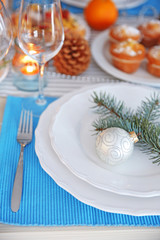 White plates with flatware on a Christmas table, close up