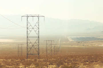 High voltage lines are held aloft by giant power towers leading to the station of solar energy in the middle of the desert.