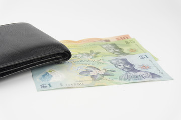 Black leather wallet with brunei money on white background