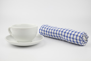 Empty white coffee cup with blue and white checkered napkin on white background