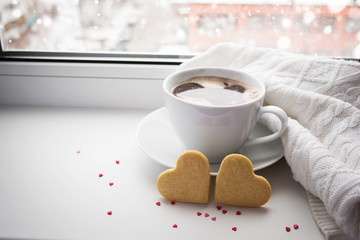 Two sponge heart and a cup of hot coffee on the window