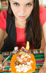Beautiful young girl tasting a delicious fish ceviche, typical ecuadorian plate