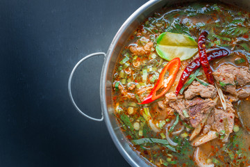 Spicy Thai style beef soup on black background - 98535623