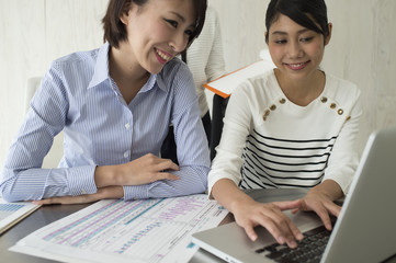 Women are talking while watching a laptop