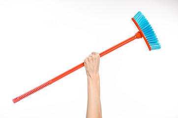 Cleaning the house topic: human hand holding a red broom isolated on a white background in studio