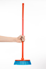 Cleaning the house topic: human hand holding a red broom isolated on a white background in studio