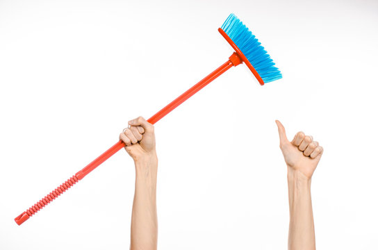 Cleaning the house topic: human hand holding a red broom isolated on a white background in studio