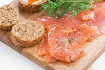 appetizers - salted salmon, red caviar, toast on wooden board