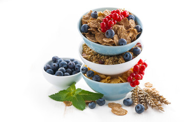 assortment of breakfast cereal in bowls and fresh berries