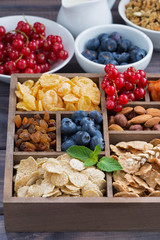breakfast cereal and other ingredients in a wooden box, vertical