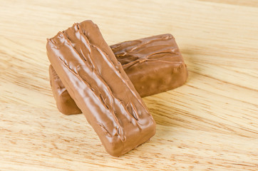 Chocolate bar on wooden background.
