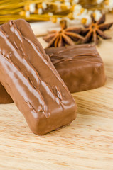 Chocolate bar on wooden background.